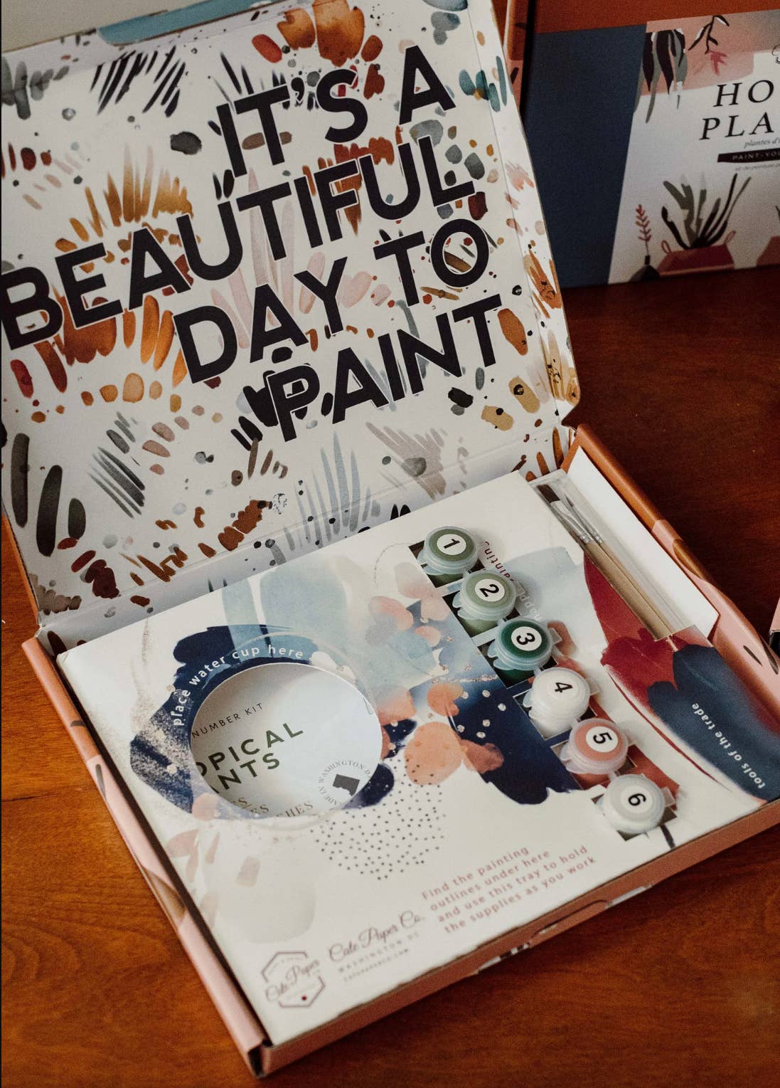 Painting kit with 'It's a Beautiful Day to Paint' text on the lid