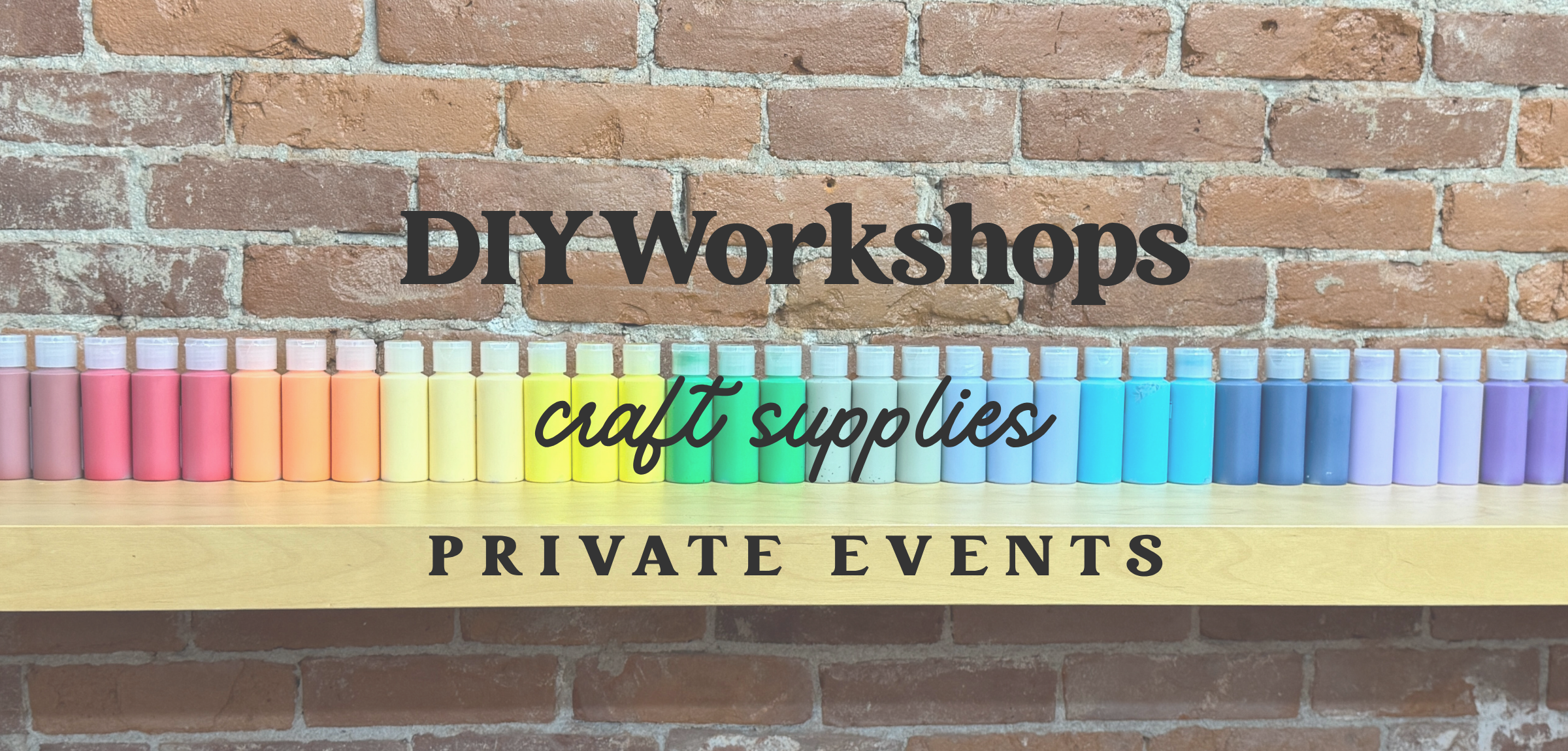 Colorful sign with text 'DIY Workshops', 'craft supplies', and 'Private Events' against a brick wall background.