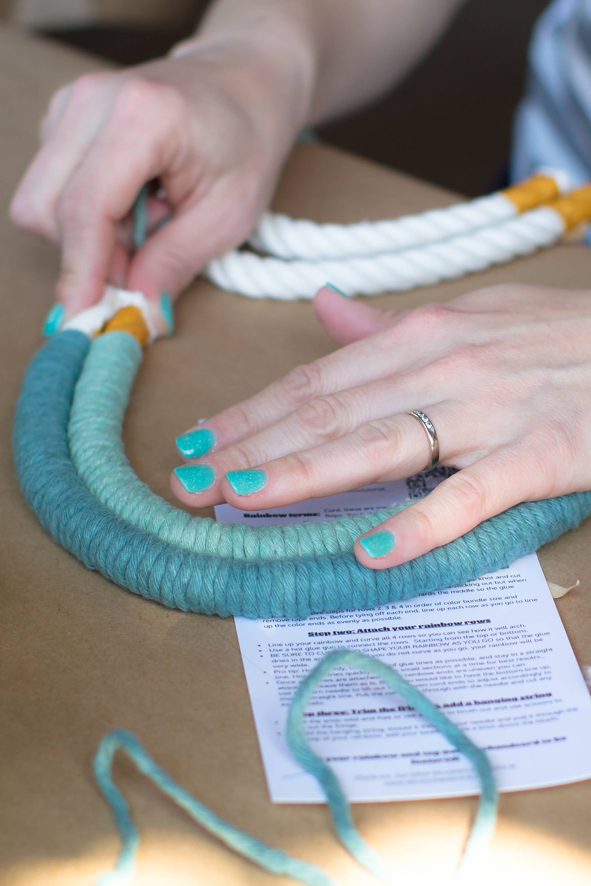 Person working with yarn on a cardboard surface